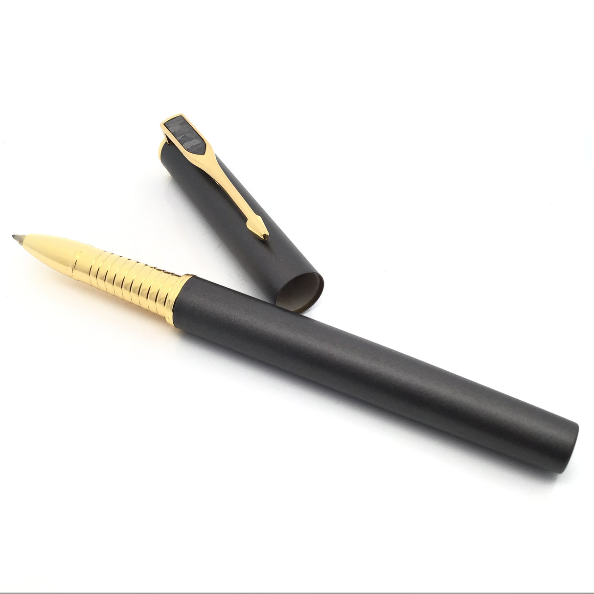 Overhead angle of Muonionalusta meteorite pen, gold ribbed grip forward and black cap resting behind it