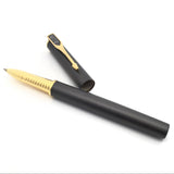 Overhead angle of Muonionalusta meteorite pen, gold ribbed grip forward and black cap resting behind it