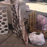 Angled view of the 21-hole serpentine onyx wine rack showing slab thickness and tapered shape