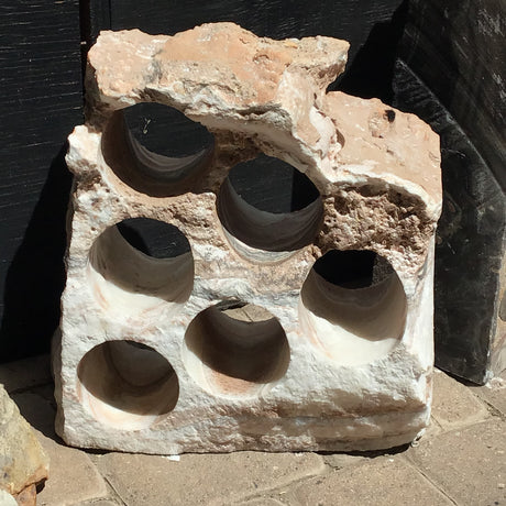 Six-hole rustic onyx wine rack in pale white and blush stone with a rugged unpolished top edge