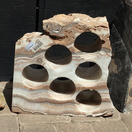 Rustic onyx wine rack with 6 holes and horizontal brown and cream banding across a rough-edged stone slab