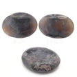 Three gray-purple agate palm stones with amber edges and mossy inclusions on white