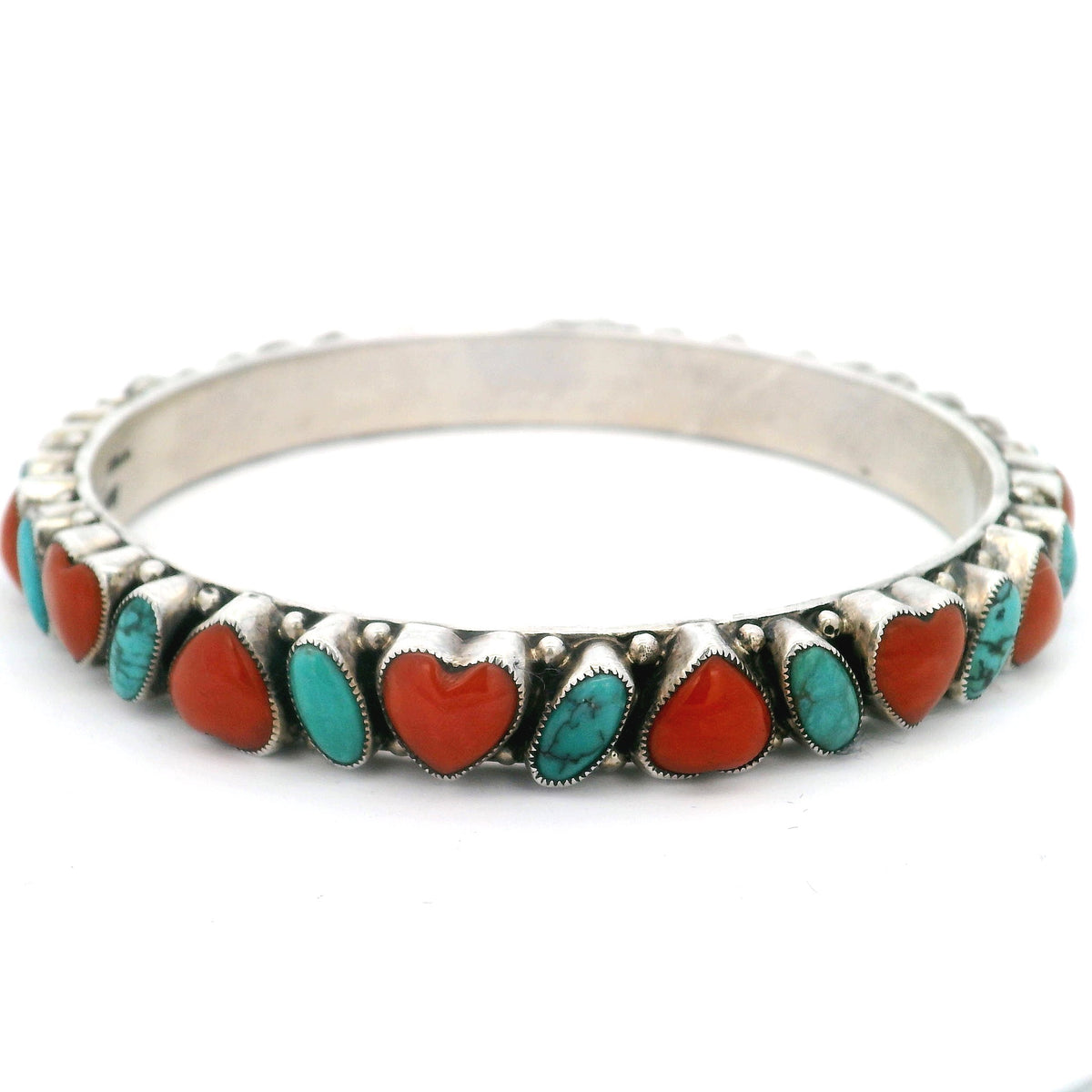 Turquoise and coral heart bangle bracelet, angled view of scalloped silver bezels and beading