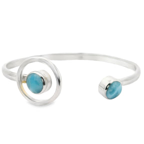 Larimar cuff bracelet with two round stones on a simple silver band, featuring a halo design on one end.