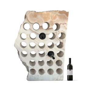 Onyx wine rack in white with caramel, featuring 27 circular holes for wine bottles, displayed with a wine bottle beside it.