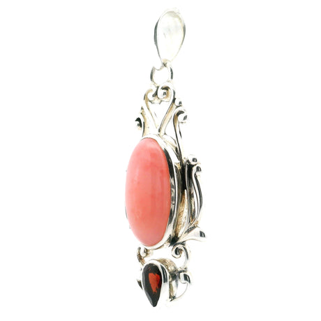 Pink opal pendant with oval cabochon and faceted garnet reverse pear, set in 925 sterling silver with filigree design.