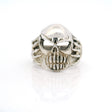 Sterling silver skull ring with bared teeth and skeletal hands at the sides, front view
