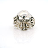 Sterling silver skull ring with bared teeth and skeletal hands at the sides, front view