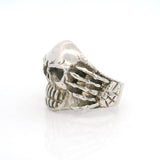 Sterling silver cracked skull ring, side view showing skeletal hand gripping the band