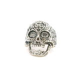 Sterling silver sugar skull ring with floral engraved detail and hollow eye sockets, front view