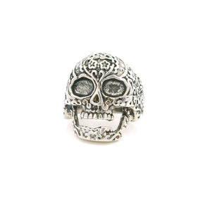 Sterling silver sugar skull ring with floral engraved detail and hollow eye sockets, front view