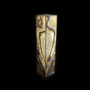 Illuminated Desert Onyx square pedestal luminary glowing with cream and amber banding against black