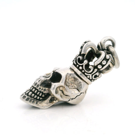 Angled view of the sterling silver skull pendant topped with an ornate scrollwork crown