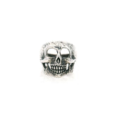 Sterling silver skull ring with hollow eye sockets and grinning teeth in an oxidized finish