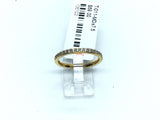 Thin gold-tone titanium band lined with white cubic zirconia pave along the crown