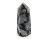 Polished Rainbow Moonstone tower point in white feldspar with bold black tourmaline patches on a white backdrop