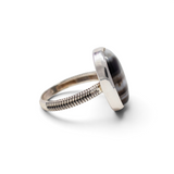 Banded agate oval cabochon ring angled to show the sterling silver bezel and rope-braid stamped band
