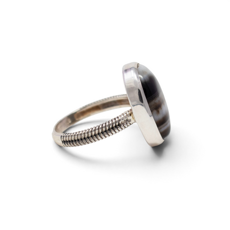Banded agate oval cabochon ring angled to show the sterling silver bezel and rope-braid stamped band