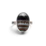 Banded agate ring, oval cabochon with black, brown and white bands in a silver step bezel, front view