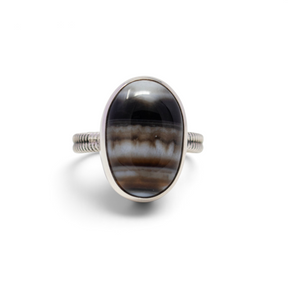 Banded agate ring, oval cabochon with black, brown and white bands in a silver step bezel, front view