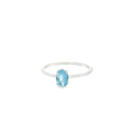 Aquamarine solitaire ring with a prong-set oval blue stone on a thin rhodium vermeil band