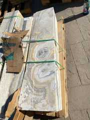 Zebra fossil onyx pillar fountain strapped to a wooden pallet, orbital eye patterns in cream and gold banding