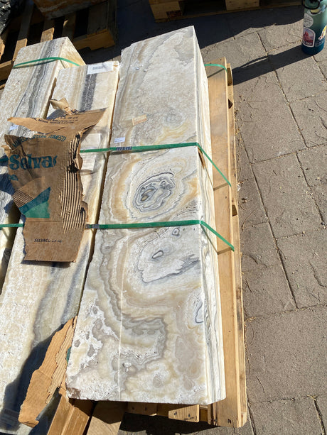 Zebra fossil onyx pillar fountain strapped to a wooden pallet, orbital eye patterns in cream and gold banding