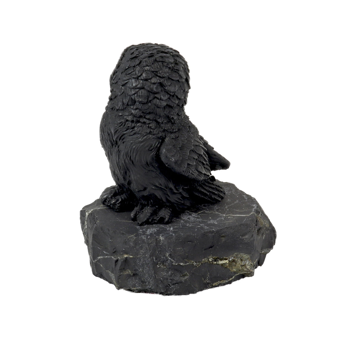Shungite owl figurine seen from the side, showing detailed carved back and wing feathers on stone base