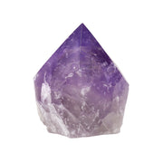 Polished amethyst point with faceted deep purple apex fading to frosted clear quartz base, front view on white
