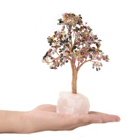 Small multi tourmaline beaded tree held in a hand for scale, copper wire trunk on a raw rose quartz base