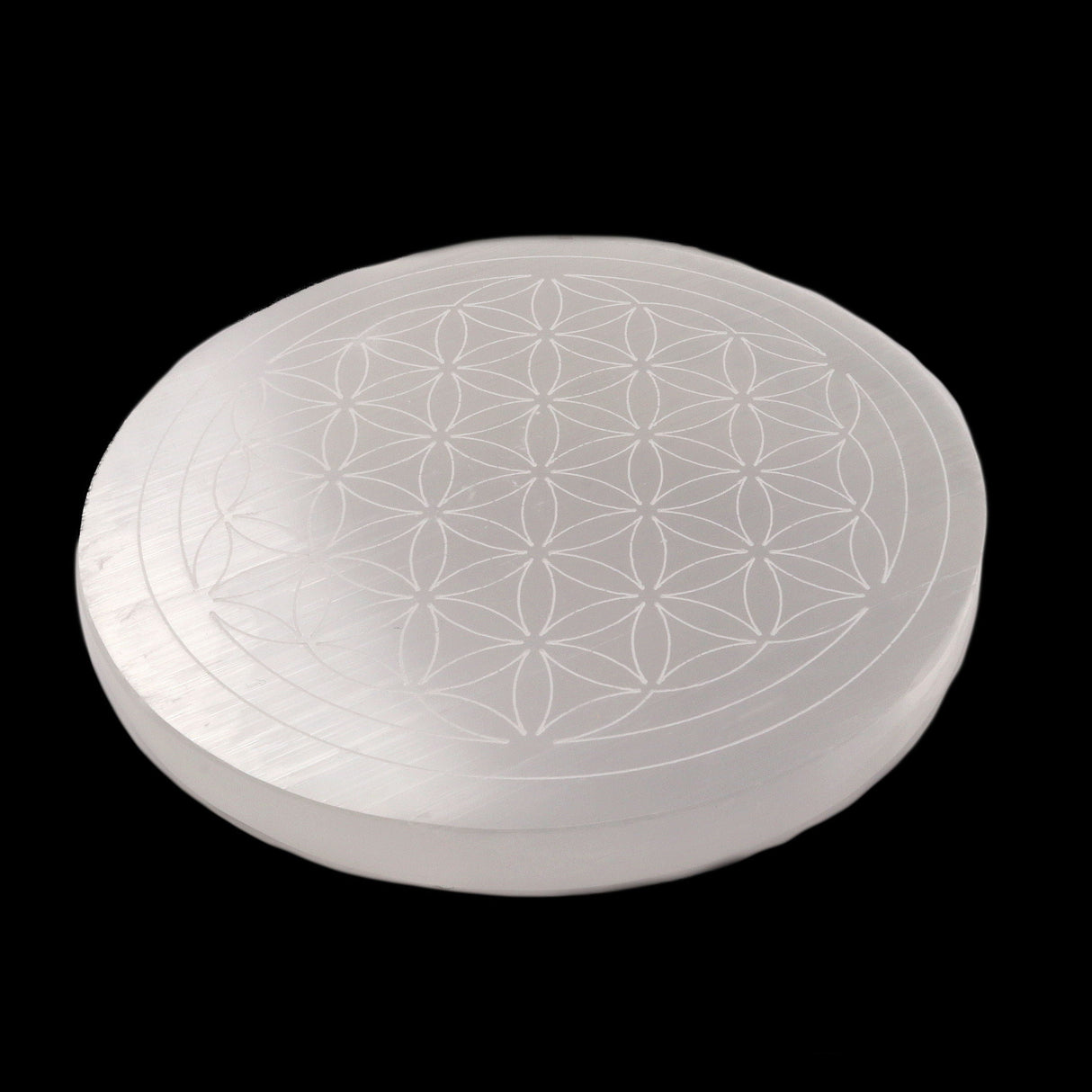 Selenite Flower of Life disc from Morocco at an angle showing fibrous white surface