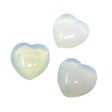 Three translucent milky-white opalite puffy hearts with a soft blue and rainbow glow