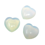 Three translucent milky-white opalite puffy hearts with a soft blue and rainbow glow