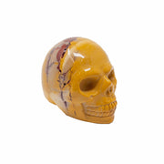 Mookaite jasper skull carving in mustard yellow with red streaks, three-quarter view facing right