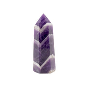 Polished chevron amethyst point standing upright with deep purple and white chevron banding