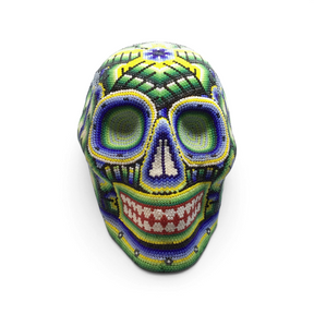 Huichol beaded skull in cool green, blue and yellow seed beads with intricate patterns, front view