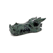 Kambaba jasper dragon skull carving in green orbicular stone, polished, three-quarter view showing snout and teeth