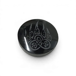 Small glossy black obsidian cabochon etched with a wolf paw print filled with Celtic knotwork symbols
