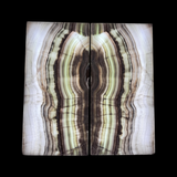 A two-panel wall art piece featuring a large abstract stone or mineral pattern with wavy vertical bands in cream, beige, brown, and dark charcoal, displayed against a dark background.