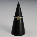 Rough freeform Egyptian tektite in a silver bezel on a thin band, shown on a black cone stand