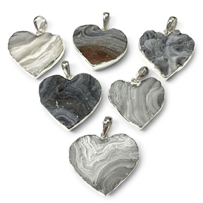 Rare Earth Gallery natural desert druze heart pendants in cool gray tones with polished silver bezels.