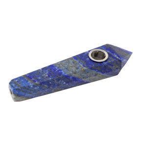 Hand carved crystal pipe in deep blue lapis lazuli with pyrite flecks, angled with bowl at upper right
