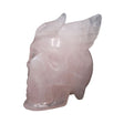 Rose quartz skull with wings carving, angled side view showing carved feathered wings