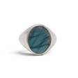 Labradorite flat-cut oval with blue-green flash set in a wide sterling silver signet ring, front view