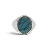 Labradorite flat-cut oval with blue-green flash set in a wide sterling silver signet ring, front view