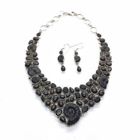 Rare Earth Gallery ammonite fossil necklace set with black spinel and black star garnet. Features spiral ammonites and mixed-cut black gemstones.