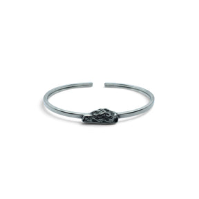 Rare Earth Gallery Campo De Cielo meteorite cuff bracelet featuring a rough freeform stone in a silver bezel setting.
