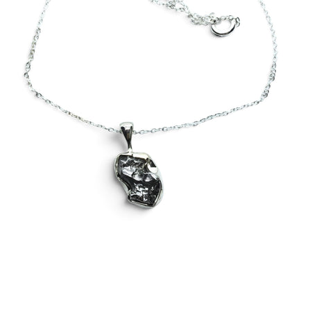 Rare Earth Gallery Campo De Cielo meteorite nugget pendant in a 925 sterling silver bezel on an 18-inch chain.