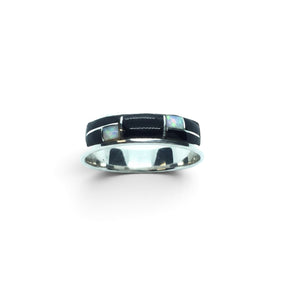 Rare Earth Gallery ring featuring black onyx and white opal inlay with silver channel detailing on a polished band.