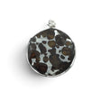Rare Earth Gallery circular Sericho pallasite meteorite pendant with a faceted sapphire in 925 sterling silver